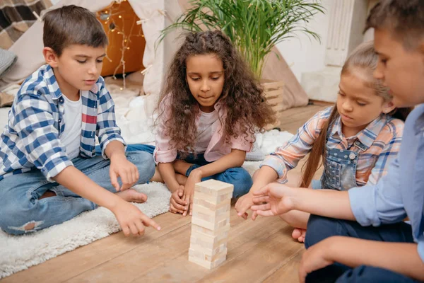 Niños jugando bloques de madera juego - foto de stock