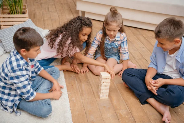 Niños jugando bloques de madera juego - foto de stock