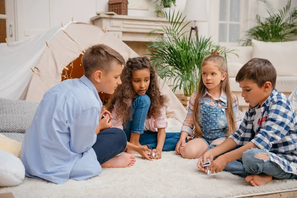 Niños multiculturales jugando dominó - foto de stock