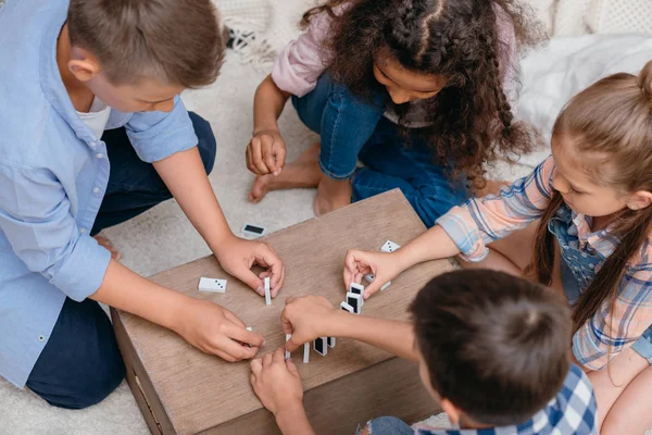 Niños multiculturales jugando dominó - foto de stock