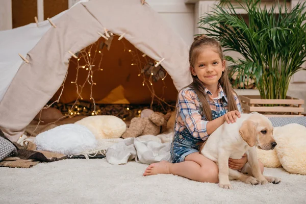 Little girl and labrador puppy — Stock Photo