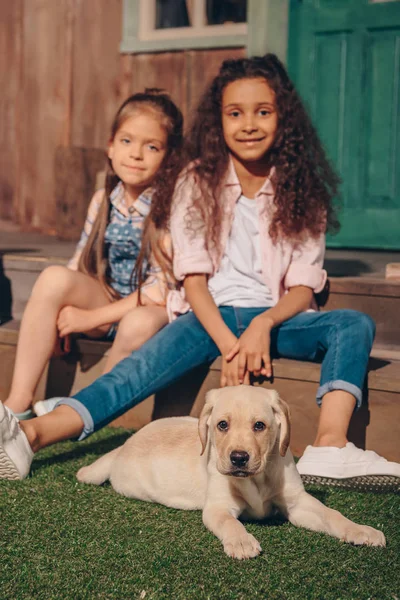 Multiethnic girls with puppy — Stock Photo