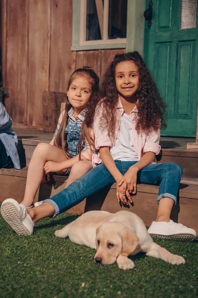 Multiethnic girls with puppy — Stock Photo