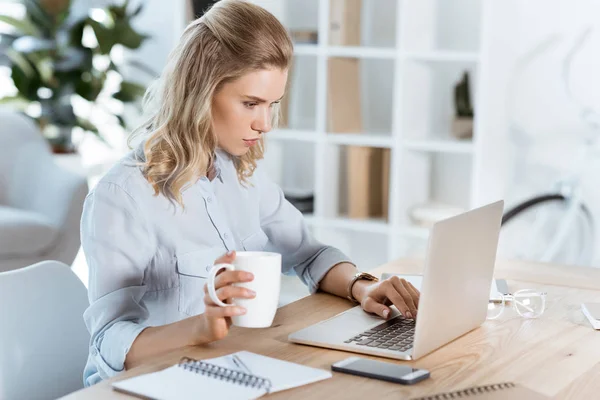 Geschäftsfrau tippt im Büro auf Laptop — Stockfoto