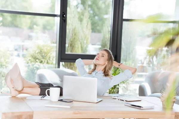 Mujer de negocios descansando en el lugar de trabajo - foto de stock