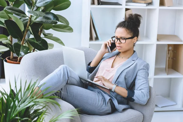 Mujer de negocios afroamericana hablando en smartphone - foto de stock