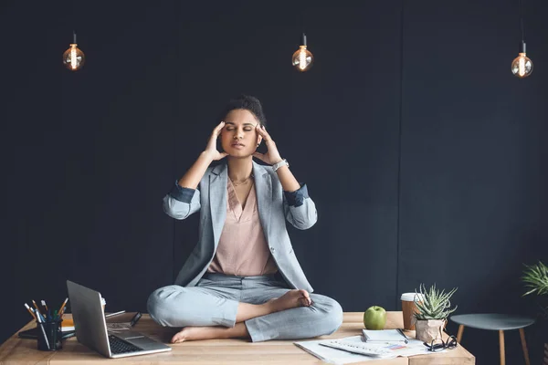 Mujer de negocios afroamericana mediando en el cargo - foto de stock