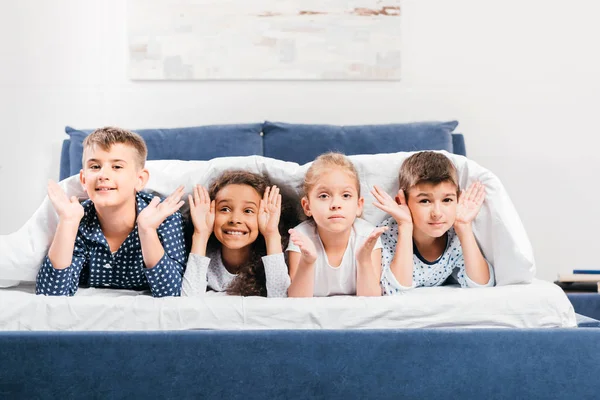 Multicultural children lying in bed — Stock Photo