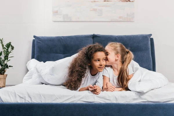 Meninas multiculturais fofocando na cama — Fotografia de Stock