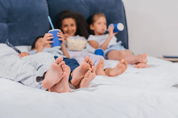 Multikulti-Kinder ruhen sich auf dem Bett aus — Stockfoto