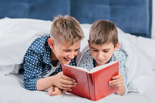 Chicos leyendo libro juntos - foto de stock