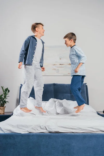 Petits garçons sautant sur le lit — Photo de stock