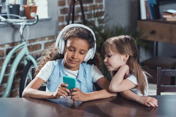 Niñas multiculturales con dispositivos digitales - foto de stock