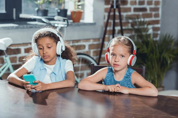 Muchachas multiculturales en auriculares - foto de stock