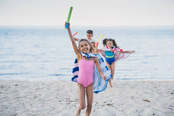 Niños multiculturales con juguetes de agua - foto de stock