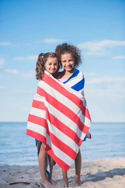 Multicultural girls in towel on beach — Stock Photo