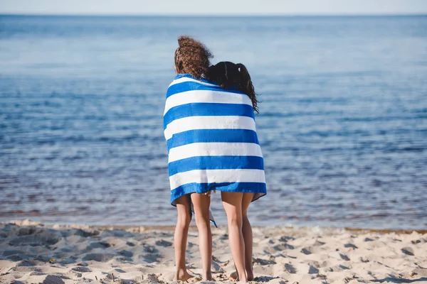 Chicas en toalla de pie en la playa - foto de stock