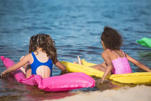 Chicas en colchones inflables en el mar - foto de stock