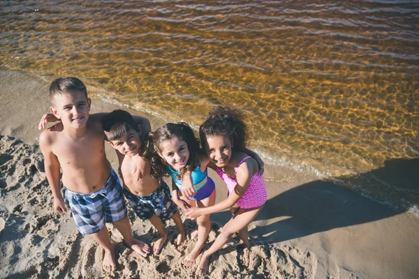 Niños multiculturales en trajes de baño en la playa - foto de stock