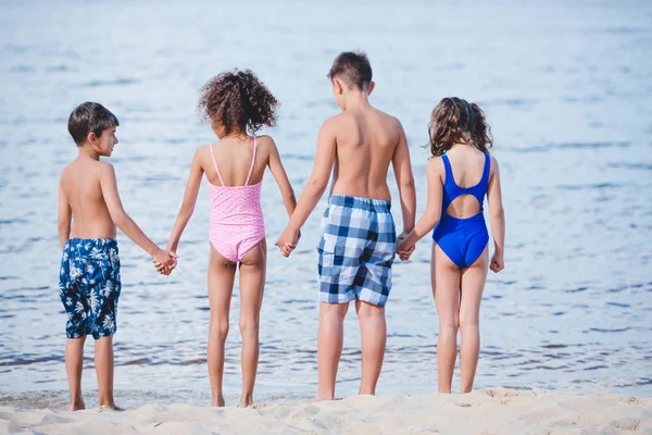 Enfants debout sur un cordon sableux — Photo de stock