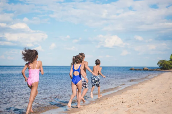 Дети бегают по песчаному пляжу — стоковое фото