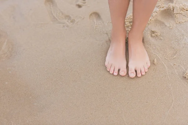 Niño de pie en la playa de arena - foto de stock