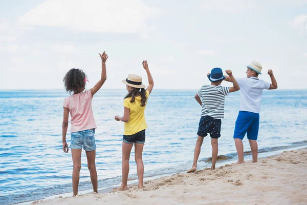 Kids throwing stones at seaside — Stock Photo