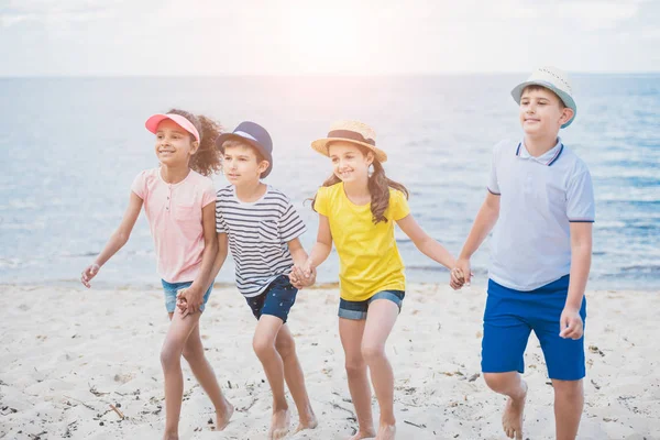 Enfants multiculturels marchant sur la plage — Photo de stock