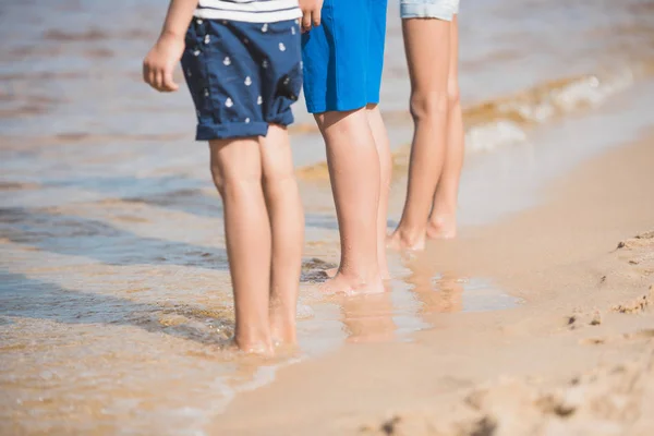 Niños de pie a orillas del mar - foto de stock