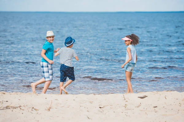 Мультикультурные дети играют на пляже — стоковое фото