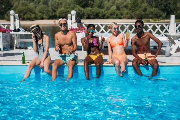 Gente multiétnica cerca de la piscina en el complejo - foto de stock