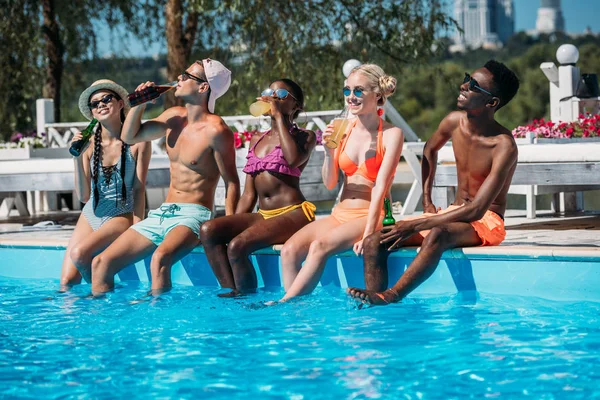 Gente multiétnica cerca de la piscina en el complejo - foto de stock