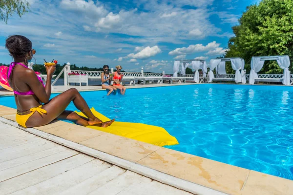 Multiethnic women near swimming pool — Stock Photo