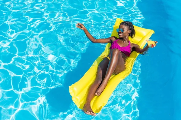 Woman on inflatable mattress in pool — Stock Photo