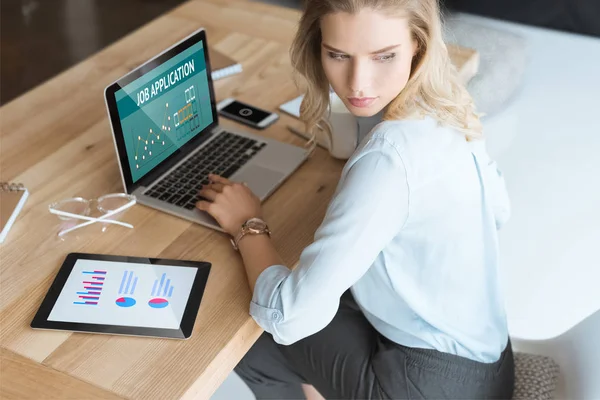 Empresaria en el lugar de trabajo con portátil - foto de stock