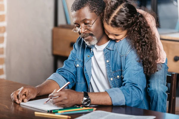 African american man drawing with daughter — Stock Photo
