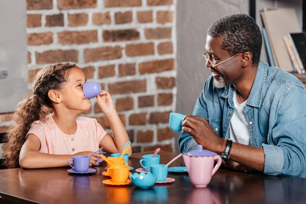 Chica teniendo té fiesta con padre - foto de stock