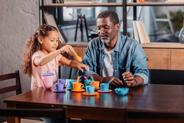 Chica teniendo té fiesta con padre - foto de stock