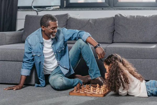 Chica jugando ajedrez con padre - foto de stock