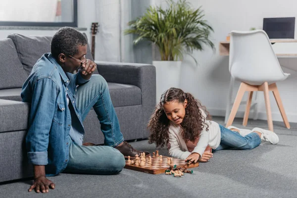 Girl playing chess with father — Stock Photo