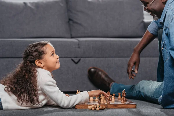 Chica jugando ajedrez con padre - foto de stock