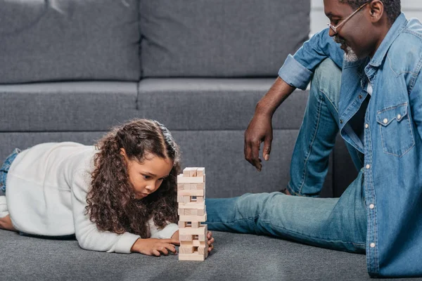 Chica jugando bloques juego con padre - foto de stock