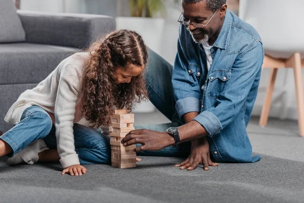 Girl playing blocks game with father — Stock Photo