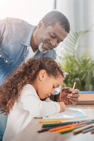 Afro-américaine fille dessin avec père — Photo de stock