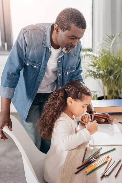 African american girl drawing with father — Stock Photo