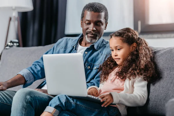 Padre con hija usando el ordenador portátil - foto de stock