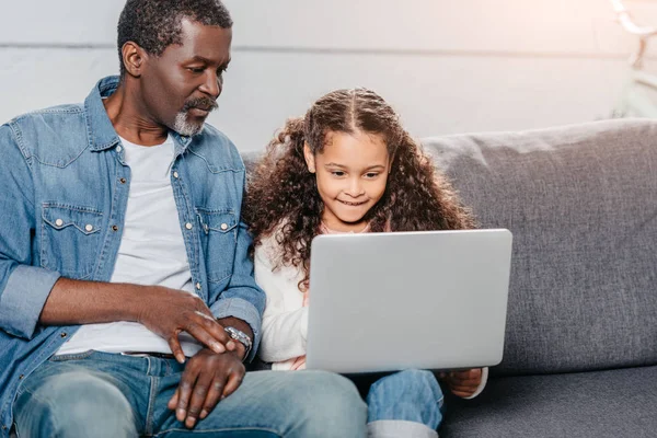 Padre con hija usando el ordenador portátil - foto de stock