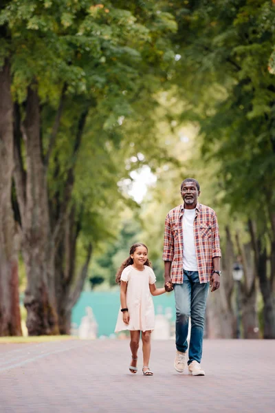 Girl holding hands with grandfather — Stock Photo
