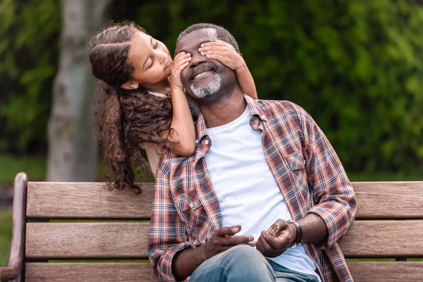 Girl closing eyes of her grandfather — Stock Photo