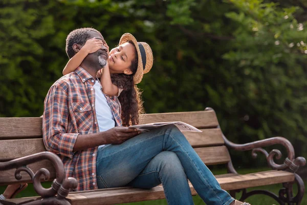 Girl closing eyes of her grandfather — Stock Photo